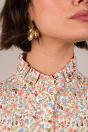 Robe Élia de la marque IT HIPPIE, en tissu léger avec motif floral, portée sur un fond blanc avec détails élégants.
