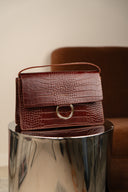 Sac en cuir Bordeaux Firmin de la maroquinerie IT HIPPIE, avec poignées et finition élégante.