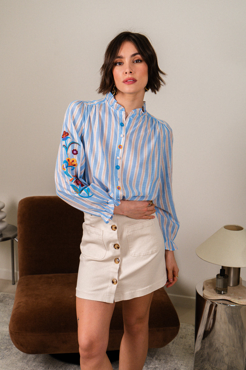 Jupe Tara de IT HIPPIE, style bohème, en tissu léger avec motifs floraux, portée avec ceinture en cuir brun.