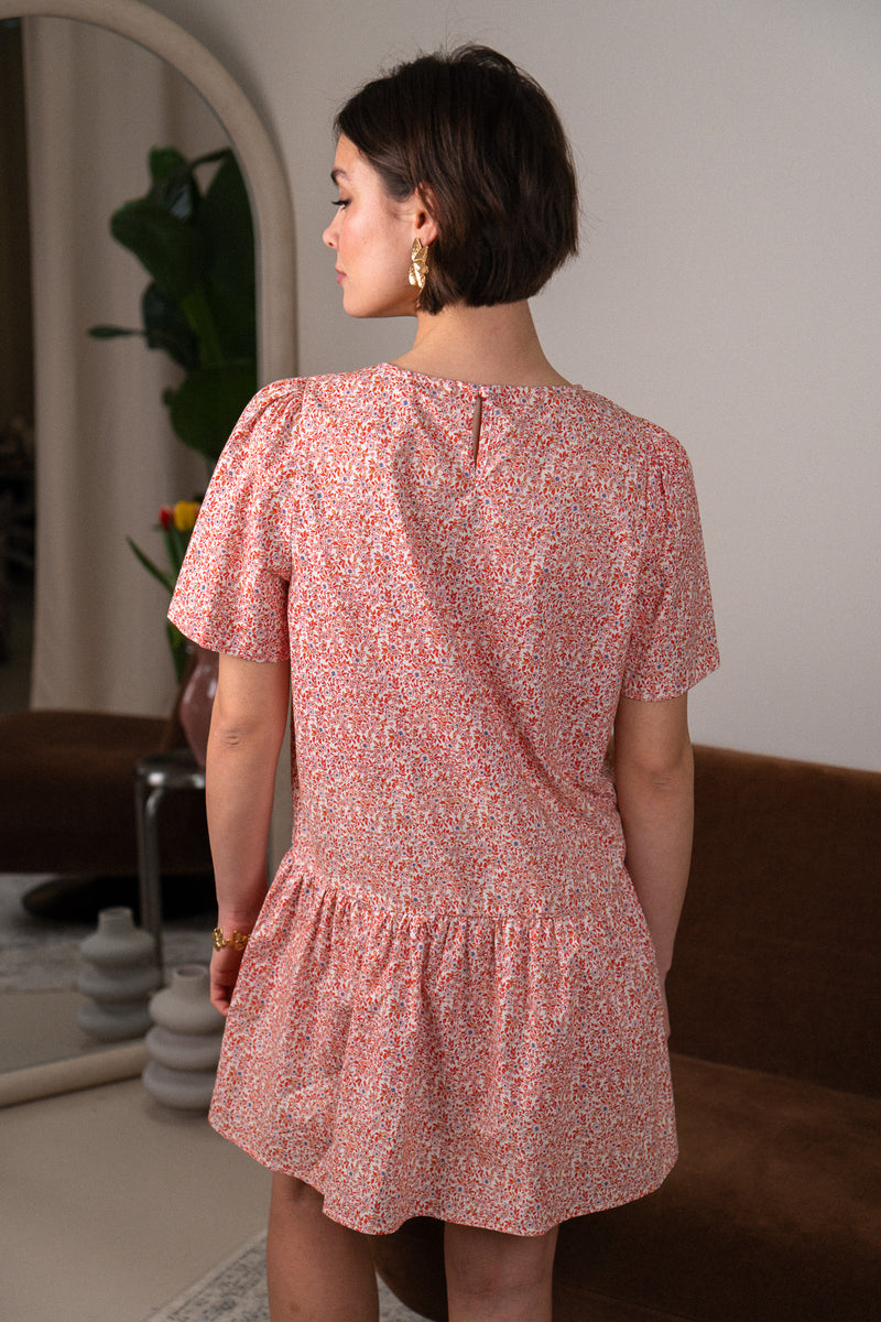 Robe Léa de la marque IT HIPPIE, en tissu léger avec motifs floraux et décolleté en V, portée avec des accessoires.